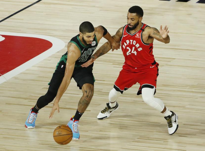 Pemain Boston Celtic Jayson Tatum (kiri) membawa bola dihalangi pemain Toronto Raptors Norman Powell dalam pertandingan play-off NBA, pekan ini.