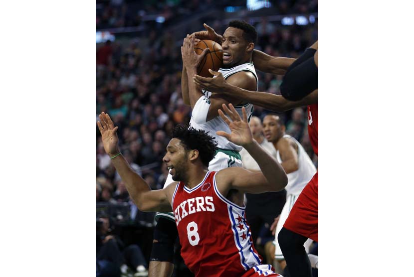 Pemain Boston Celtics, Evan Turner (tengah atas), berada di bawah kepungan pemain Philadelphia 76ers' dalam laga NBA di Boston, Amerika Serikat, Rabu (25/11). 