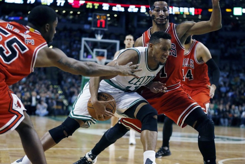 Pemain Boston Celtics, Evan Turner (tengah), mencoba melewati adangan pemain Chicago Bulls dalam pertandingan basket NBA di Boston pada Rabu (9/12). 