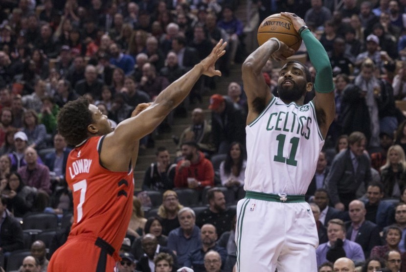 Pemain Boston Celtics, Kyrie Irving (kanan), melepaskan tembakan di tengah hadangan pemain Toronto Raptors, Kyle Lowry, dalam pertandingan basket NBA di Toronto pada Selasa (6/2). 