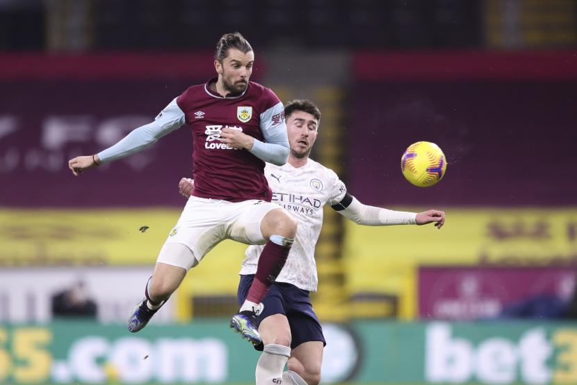 Pemain Burnley Jay Rodriguez (kiri) berduel dengan pemain Manchester City Aymeric Laporte ketika kedua tim bertarung di Turf Moor, Kamis (4/2).