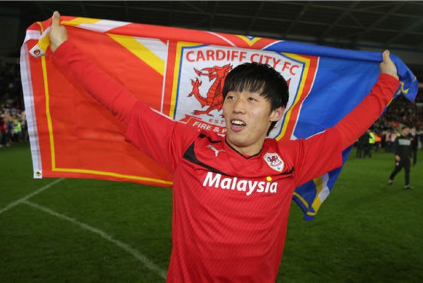 Pemain Cardiff City asal Korea, Kim Bo-Kyung, melakukan selebrasi usai meraih tiket promosi ke Liga Primer Inggris setelah menghadapi Charlton di Cardiff City Stadium, Wales, Selasa (16/4). 