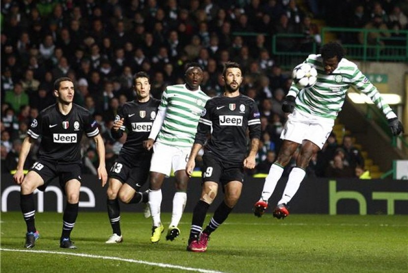 Pemain Celtic, Efe Ambrose (kanan), melepaskan sundulan yang berhasil dijinakan kiper Juventus, Gianluigi Buffon (tak terlihat), di leg pertama babak 16 besar Liga Champions di Celtic Park, Glasgow, Selasa (12/2).  