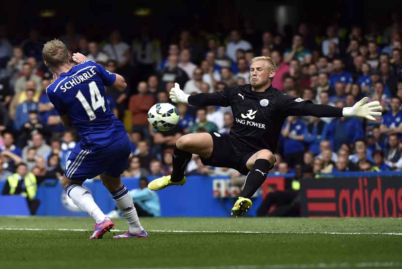 Pemain Chelsea, Andre Schurrle (kiri), berebut bola dengan kiper Leicester City, Kasper Schmeichel, dalam laga Liga Primer Inggris di Stamford Bridge, London, Sabtu (23/8). 