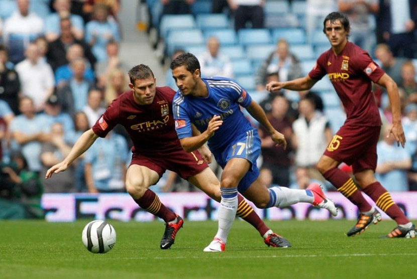 Pemain Chelsea, Eden Hazard (tengah) berupaya melepaskan diri dari hadangan pemain Manchester City dalam laga Community Shield, Ahad (12/8) 2012. 