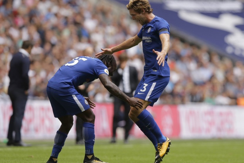 Pemain Chelsea Marcos Alonso (kanan) merayakan kemenangan dengan rekan setimnya Victor Moses usai mencetak gol melawan Tottenham Hotspur di Stadium Wembley, London, (20/8).