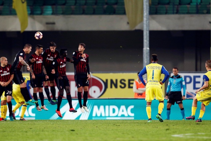 Pemain Chievo Verona Valter Bisa mencoba mencetak gol ke gawang AC Milan, Senin (17/10).