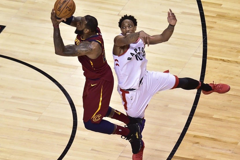  Pemain Cleveland Cavaliers LeBron James (23) mencoba melakukan tembakan dengan penjagaan dari guard Toronto Raptors, DeMar DeRozan (10) pada gim pertama semifinal wilayah timur di Toronto, Selasa (1/5) waktu setempat