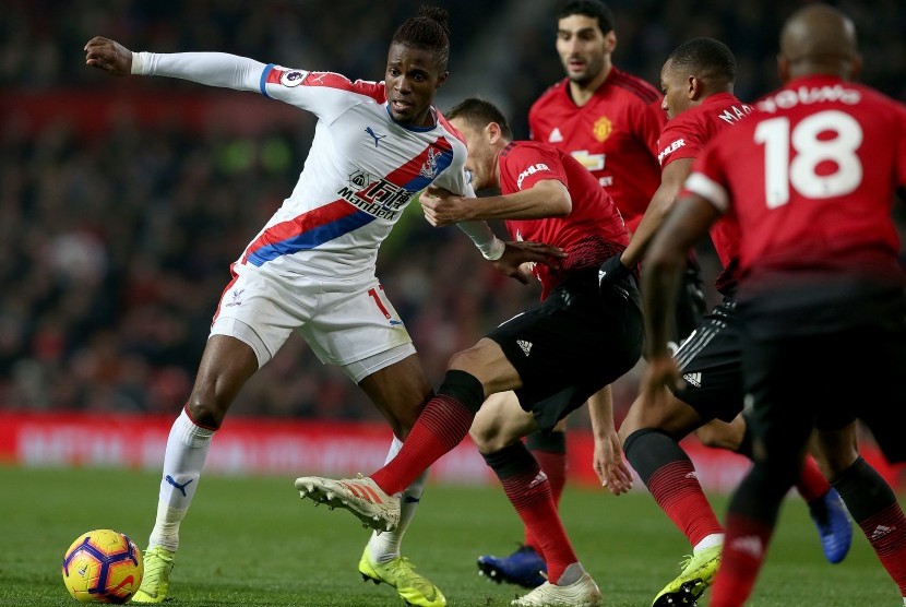 Pemain Crystal Palace Wifried Zaha (kiri) diadang oleh pemain Manchester United Nemanja Matic (tengah). 