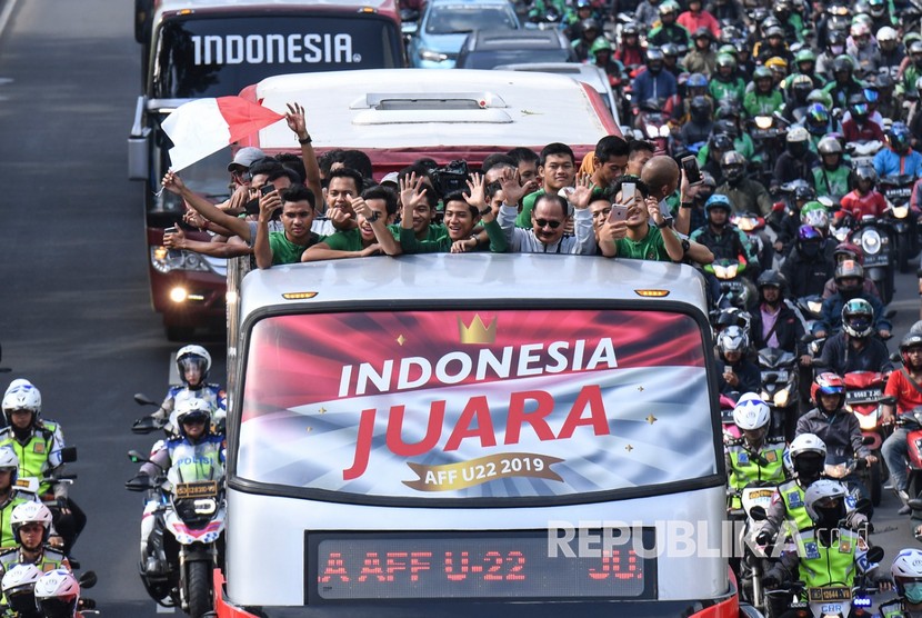 Pemain dan ofisial Timnas U-22 Indonesia menaiki bus tingkat ketika mengikuti konvoi menuju Istana Negara saat melintas di Jalan Sudirman, Jakarta, Kamis (28/2/2019). 