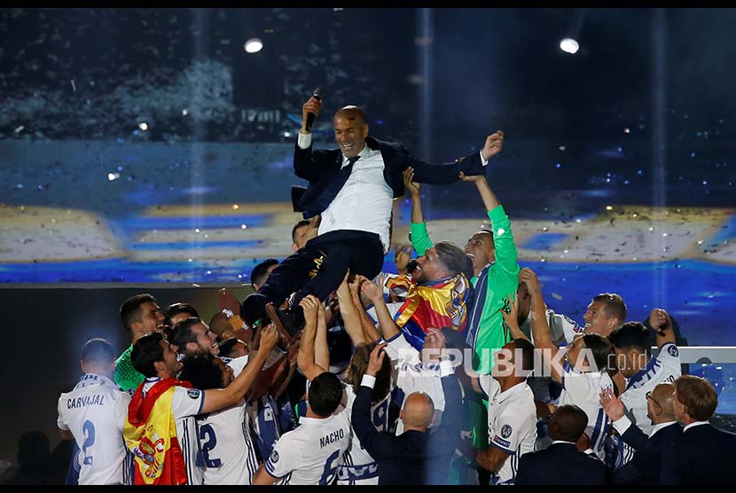 Pemain dan tim Real Madrid melemparkan pelatih mereka ke udara saat merayakan kemenangan ke-12 Real Madrid di ajang Liga Champions Eropa. 