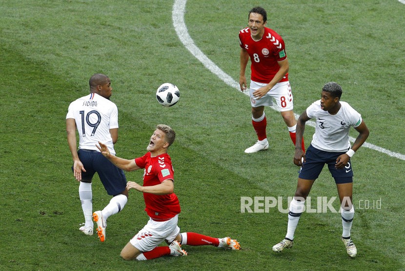 Pemain Denmark Andreas Cornelius berebut bola dengan pemain Prancis Djibril Sidibe pada pertandingan grup C Piala Dunia 2018 antara Denmark dan Prancis di Stadion Luzhniki di Moskow, Rusia, Selasa (26/6).