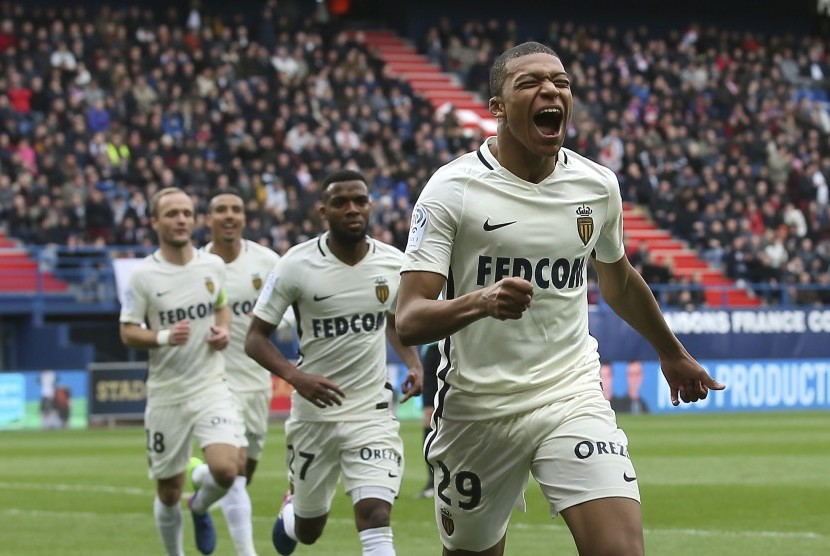 Pemain depan AS Monaco, Kylian Mbappe merayakan golnya ke gawang Caen pada laga Ligue 1 di Caen, Ahad (19/3). Monaco menang 3-0.