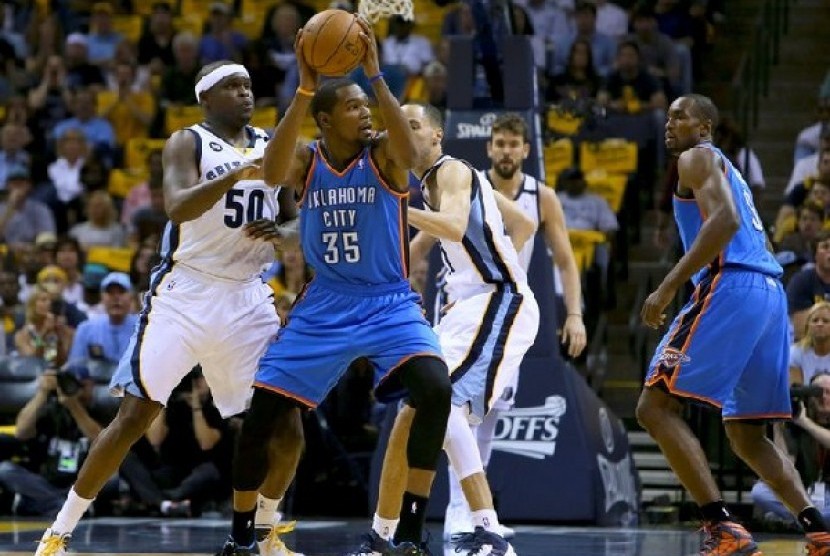 Pemain depan Grizzlies Kevin Durant sedang membawa bola dan dihadang sejumlah pemain Thunder 