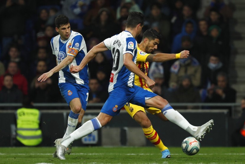 Pemain Espanyol Bernardo Espinosa menjaga striker Barcelona Luis Suarez yang mencoba melepaskan tendangan. Espanyol menahan imbang BArcelona 2-2.