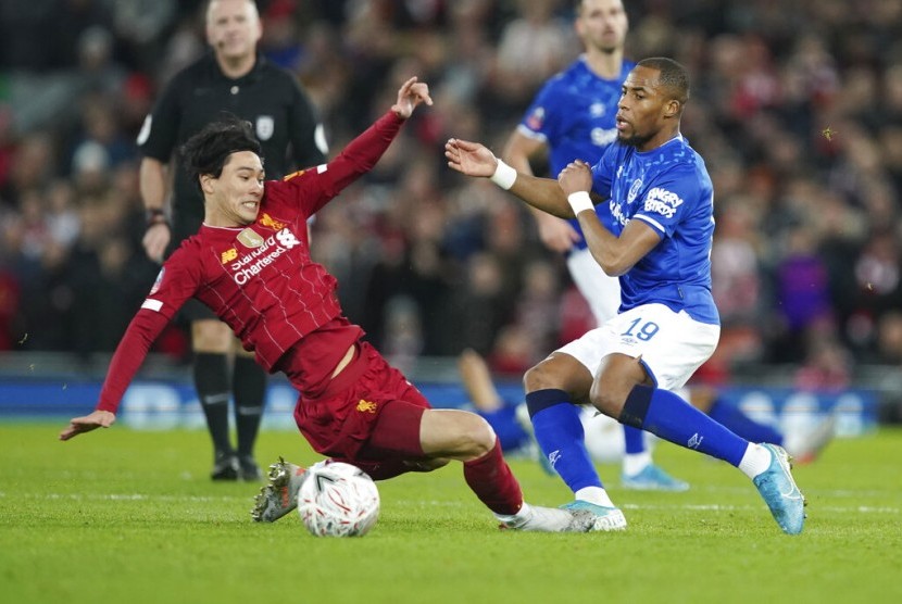 Pemain Everton Djibril Sidibe (kanan) berusaha menghentikan gerakan penyerang Liverpool Takumi Minamino. Wali Kota Liverpool mengizinkan pertandingan kedua tim berlangsung di Goodison Park, markas Everton.