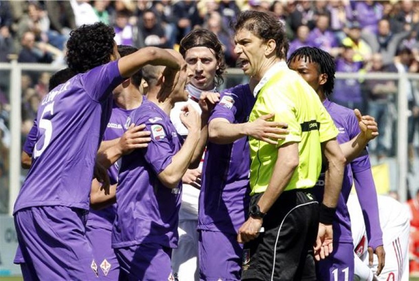 Pemain Fiorentina memprotes keputusan wasit Paolo Tagliavento (kanan) saat menghadapi AC Milan di laga Serie A Italia di Stadion Artemio Franchi, Florence, Ahad (7/4). 