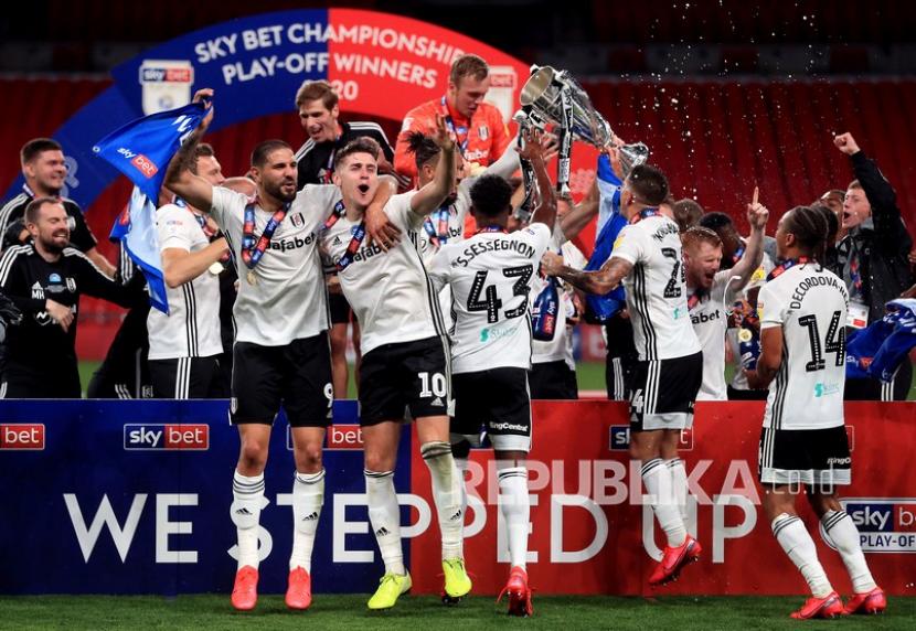 Pemain  Fulham merayakan dengan trofi setelah memenangkan final sepak bola Play Off Kejuaraan Inggris antara Fulham dan Brentford, di Stadion Wembley, di London, Selasa (4/8/2020). 