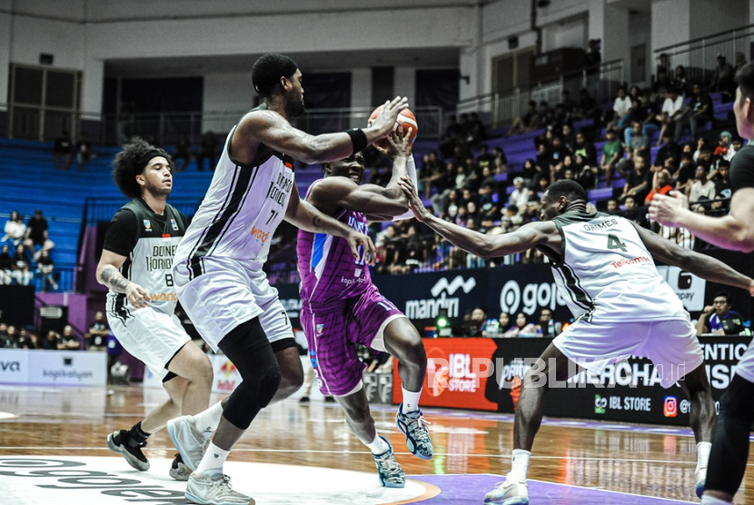 Pemain Hangtuah Samuel Adewunmi berusaha melewati penjagaan Borneo Hornbills dalam lanjutan IBL Gopay 2025 di GOR Ciracas, Jakarta Timur, Ahad (9/3/2025).