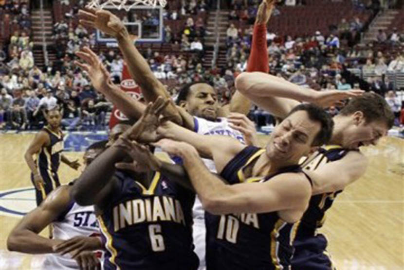 Pemain Indiana Pacers (hitam) mengepung pemain lawan yang coba melepaskan tembakan dalam di laga NBA.