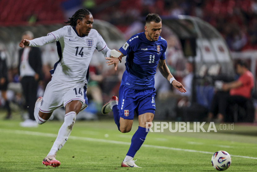 Pemain Inggris Djed Spence (kiri) berebut bola dengan pemain Serbia Filip Kostic dalam pertandingan kualifikasi Piala Dunia Grup K antara Serbia dan Inggris di Stadion Rajko Mitic, Beograd, Serbia, Rabu (10/9/2025) dini hari WIB.