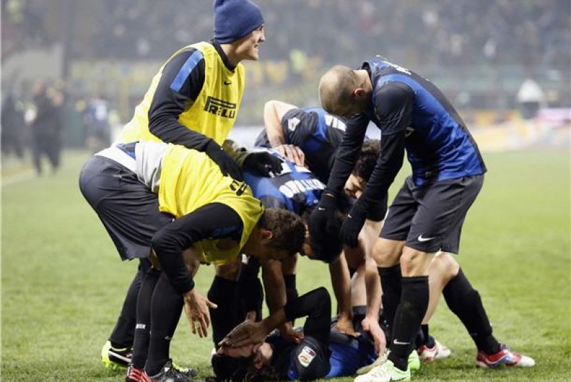 Pemain Inter Milan, Ezequiel Schelotto (bawah), melakukan selebrasi usai menjebol gawang AC Milan di laga Seri A Italia di Stadion San Siro, Milan, Ahad (24/2). 