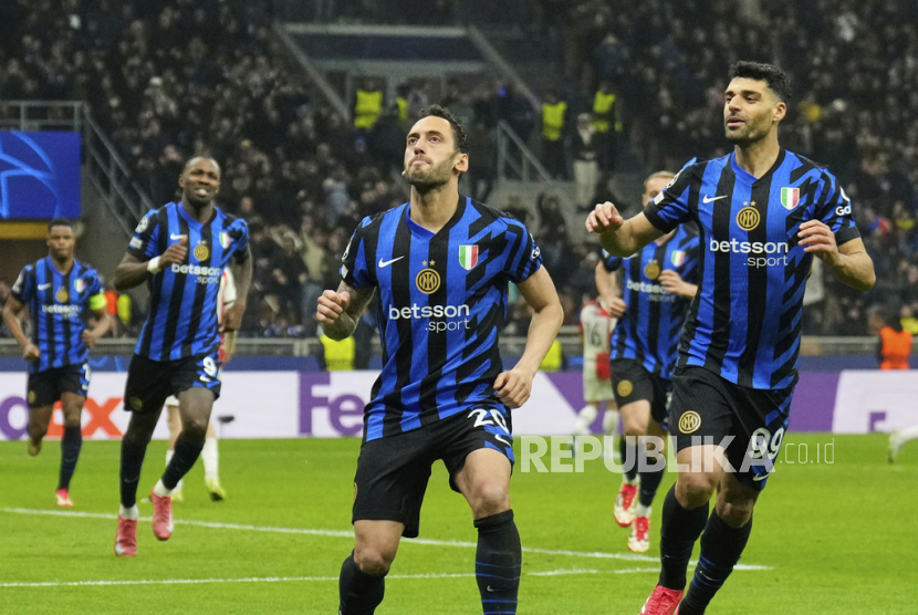 Pemain Inter Milan Hakan Calhanoglu, tengah, merayakan gol kedua timnya ke gawang Feyenoord dalam pertandingan leg kedua babak 16 besar Liga Champions di Giuseppe Meazza, Milan, Rabu (12/3/2025) dini hari WIB.