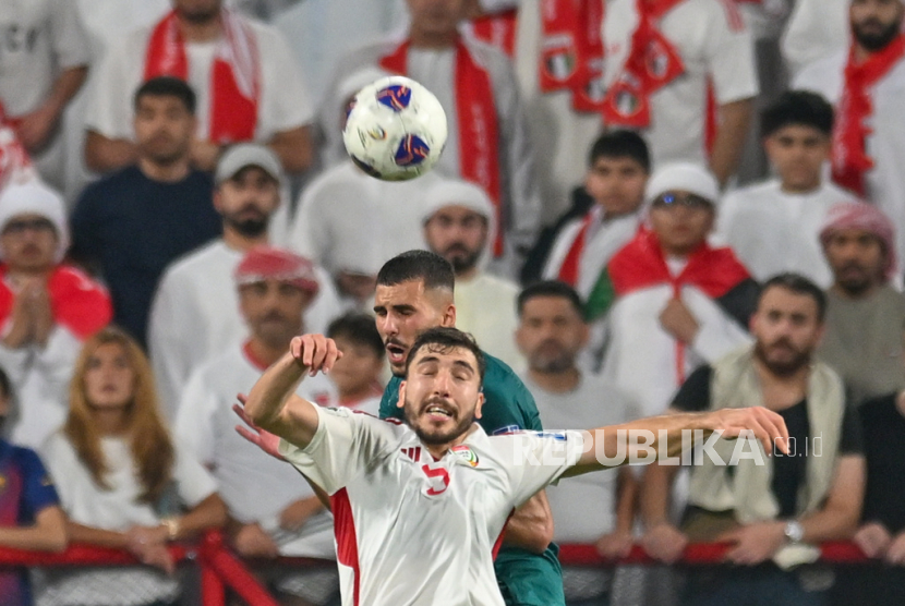 Pemain Irak Hussein Hayder Ali (belakang), dan Ali Eddine Zhir dari UEA melompat untuk merebut bola dalam pertandingan leg pertama play-off Piala Dunia 2026 antara UEA dan Irak di Abu Dhabi, Uni Emirat Arab, Jumat, 14 November 2025 dini hari WIB. 