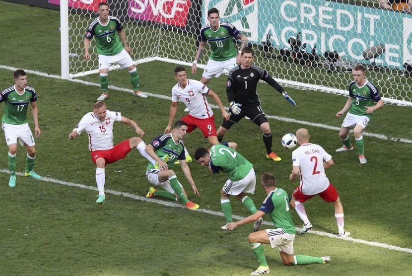 Pemain Irlandia Utara berusaha menghadang tendangan yang dilepaskan pemain Polandia, Kamil Glik (dua dari kiri), dalam pertandingan kualifikasi Grup C Piala Eropa 2016 di Allianz Riviera Stadium. 