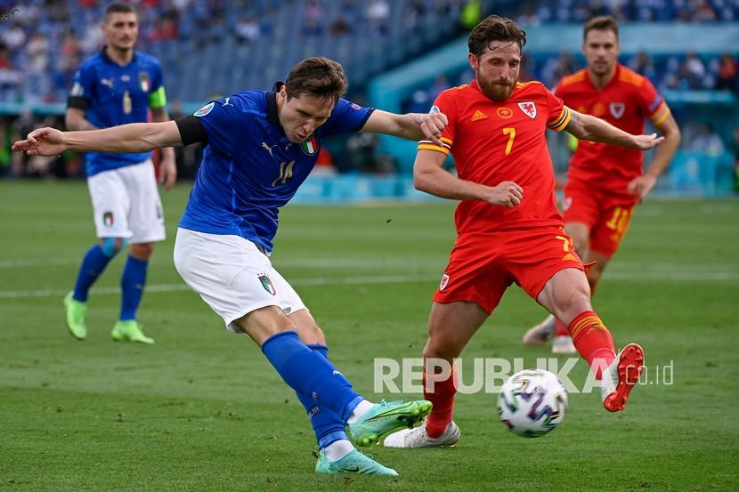 Pemain Italia Federico Chiesa menendang bola melewati  pemain Wales Joe Allen pada pertandingan Grup A Euro 2020.