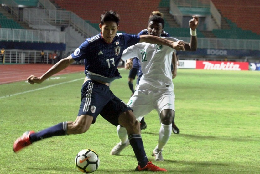 Pemain Jepang U-19 Taichi Hara (kiri) berebut bola dengan pemain Arab Saudi U-19 Mohammed Ali (kanan) pada semifinal Piala AFC U-19 di Stadion Pakansari, Bogor, Jawa Barat, Kamis (1/11/2018). Arab Saudi mengalahkan Jepang 2-0 dan melaju ke final. 