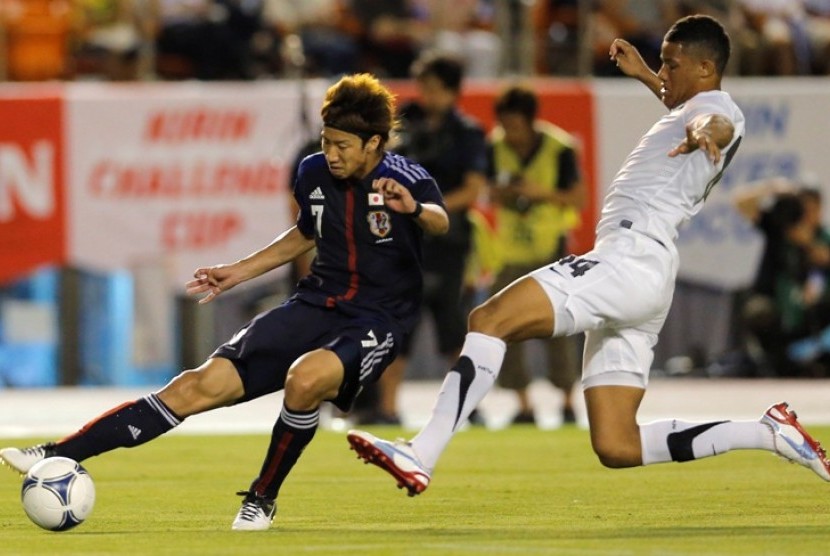  Pemain Jepang, Yuki Otsu (kiri) berebut bola dengan pemain Selandia Baru, James Musa dalam pertandingan persahabatan di Tokyo, 11 Juli 2012