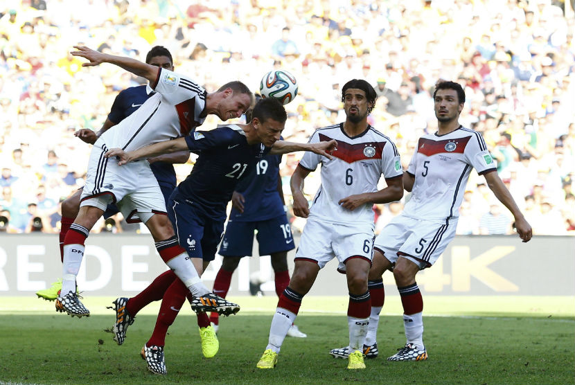 Pemain Jerman, Benedikt Hoewedes (kiri), menyapu bola saat menghadapi Prancis di laga perempat final Piala Dunia 2014 di Stadion Maracana, Rio de Janeiro, Jumat (4/7). 