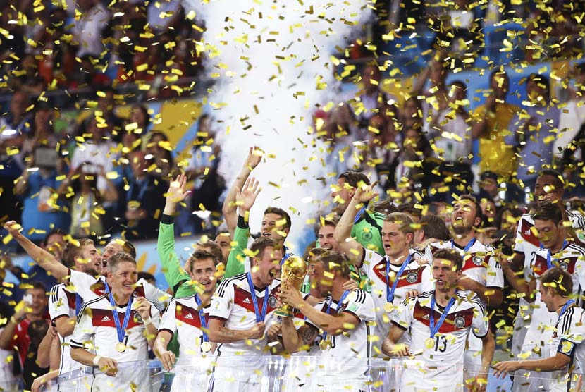 Pemain Jerman merayakan dengan trofi setelah memenangkan Piala Dunia FIFA 2014 final antara Jerman dan Argentina di Stadion Maracana, Rio de Janeiro, Brasil, Senin (14/7).   (EPA/Antonio Lacerda).