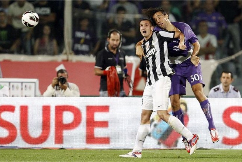 Pemain Juventus, Giorgio Chiellini (kiri), berebut bola dengan Luca Toni saat masih memperkuat Fiorentina, di sebuah laga Liga Italia.