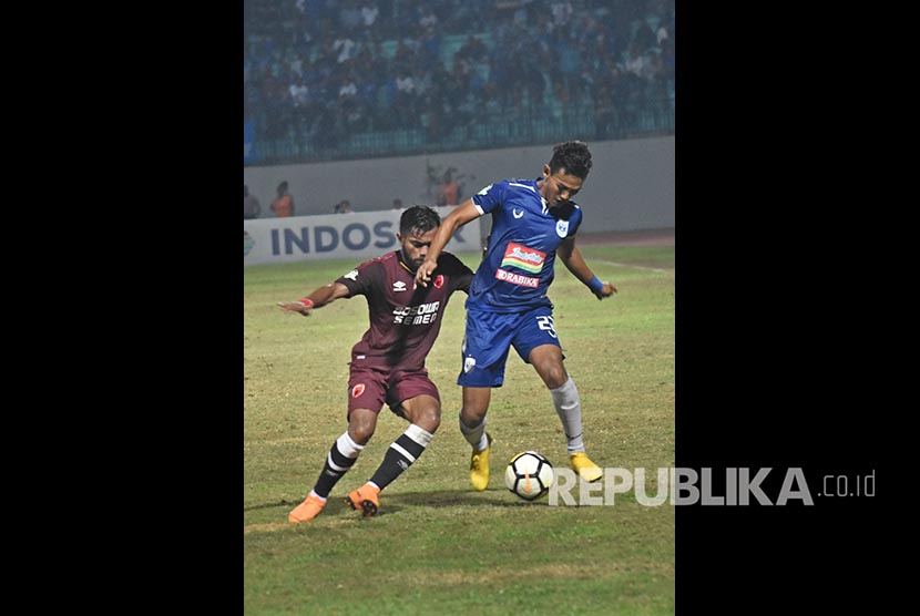 Pemain klub sepak bola PSIS Semarang Hari Nur Yulianto (kanan) berebut bola dengan pemain PSM Makassar Zulham Zamrun dalam pertandingan lanjutan Liga 1 Indonesia di Stadion Moch Soebroto, Magelang, Jawa Tengah, Senin (30/7) malam. 