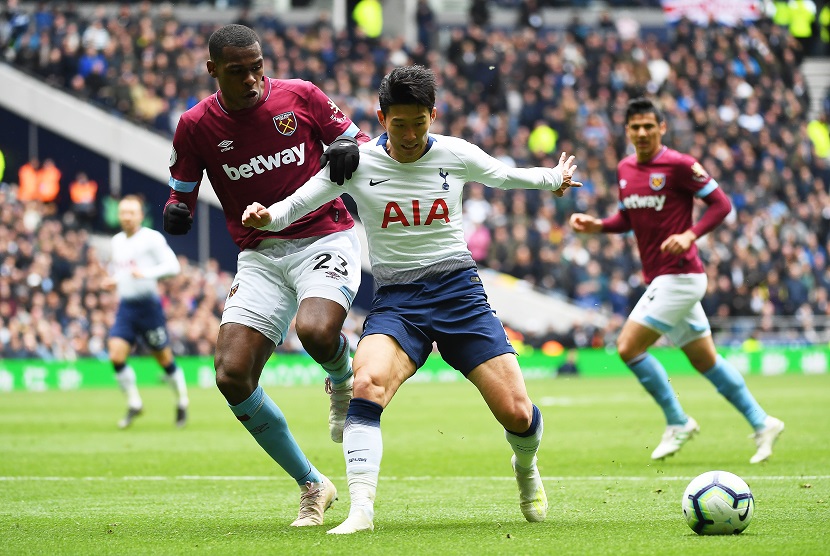 Pemain Klub West Ham, Issa Diop (kiri) sedang berebut bola dengan pemain Tottenham Hotspur Son Heung Min (tengah).