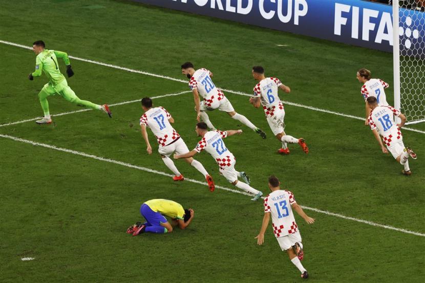  Pemain Kroasia berlari dalam perayaan saat Marquinhos dari Brasil gagal mengeksekusi  Selebrasi pemain Kroasia setelah tendangan penalti Marquinhos dari Brasil membentur tiang, yang menyebabkan Brasil tersingkir selama pertandingan sepak bola perempat final Piala Dunia FIFA 2022 antara Kroasia dan Brasil di Stadion Education City di Doha, Qatar,  Jumat (9/12/2022).di lapangan setelah tembakan penaltinya membentur tiang, yang menyebabkan Brasil tersingkir selama pertandingan sepak bola perempat final Piala Dunia FIFA 2022 antara Kroasia dan Brasil di Stadion Education City di Doha, Qatar,  Jumat (9/12/2022).