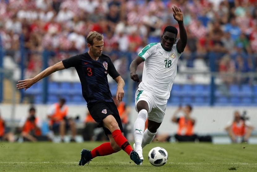 Pemain Kroasia, Ivan Strinic (kiri), terlibat duel dengan pemain Senegal, Ismaila Sarr, dalam laga internasional di Osijek, Kroasia, Jumat (8/6). 