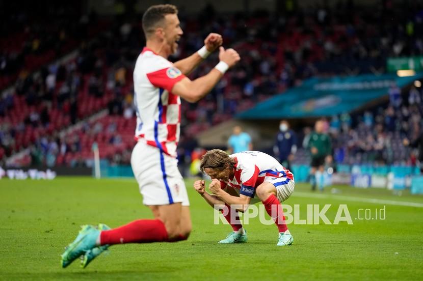 Pemain Kroasia Luka Modric, kanan, merayakan, setelah pemain Kroasia Ivan Perisic, kiri, mencetak gol pada pertandingan grup D kejuaraan sepak bola Euro 2020 antara Kroasia dan Skotlandia di Stadion Hampden Park di Glasgow,  Rabu (23/6) dini hari WIB.