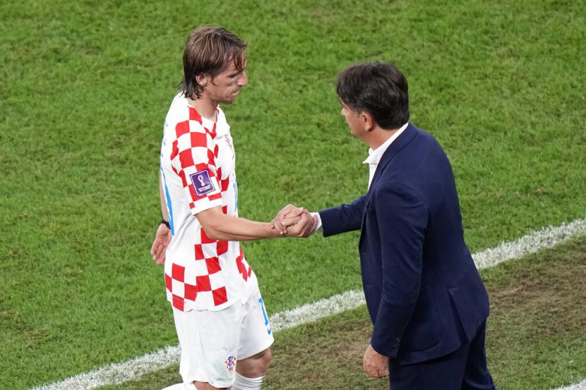 Pemain Kroasia Luka Modric (kiri) berjabat tangan dengan pelatih kepala Kroasia Zlatko Dalic setelah ia digantikan dalam pertandingan sepak bola babak 16 besar Piala Dunia antara Jepang dan Kroasia di Stadion Al Janoub di Al Wakrah, Qatar, Senin, 5 Desember 2022. 
