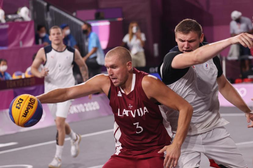 Pemain Latvia, Edgars Krumins (kiri), dijaga Ilia Karpenkov (ROC/Rusia) pada final basket 3x3 putra Olimpiade Tokyo, Rabu (28/7).