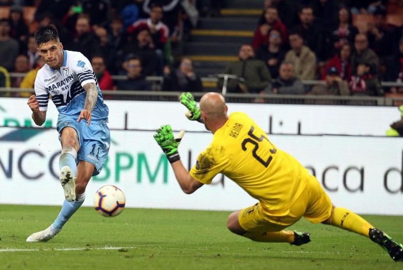 Pemain Lazio Joaquin Correa melepaskan tendangan ke penjaga gawang AC Milan Pepe Reina.