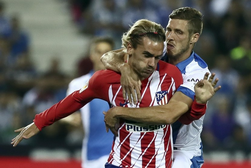 Pemain Leganes Ruben Perez (kiri) berduel dengan pemain Atletico Madrid Antoine Griezmann pada laga ketujuh La Liga antara kedua tim di Stadion Butarque, Leganes, Madrid, Spanyol, Sabtu (30/9). 