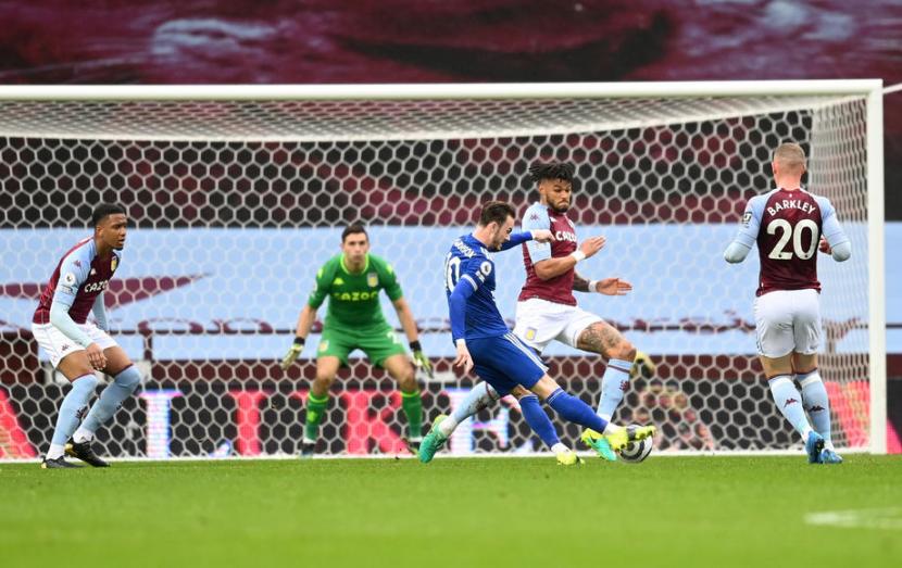 Pemain Leicester City James Maddison (kostum biru) mencetak gol ke gawang Aston Villa.