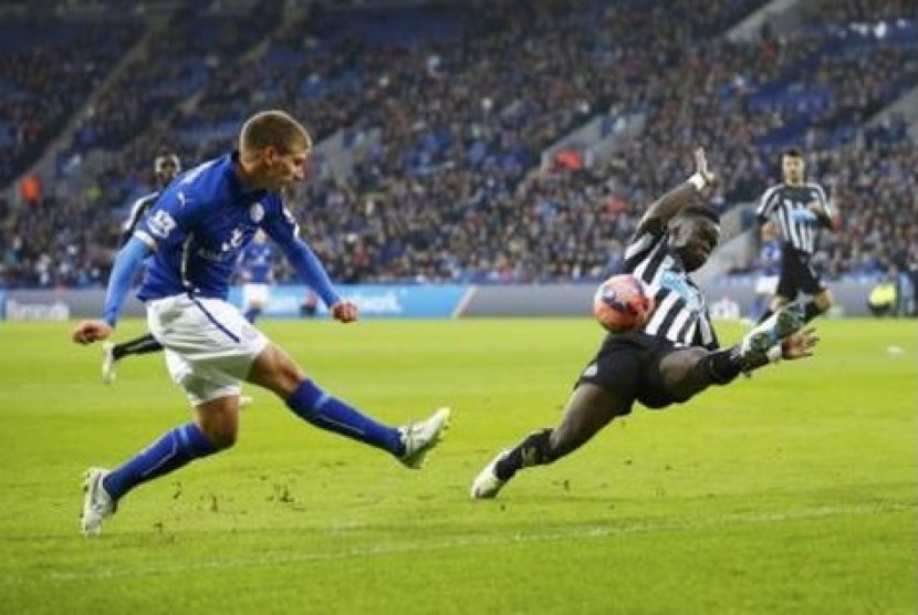 Pemain Leicester City Marc Albrighton (biru) melepaskan umpan dijaga oleh pemain Newcastle United Massadio Haidara dalam pertandingan Piala FA, Sabtu (3/1).