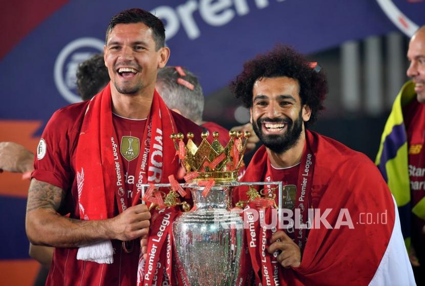 Pemain Liverpool Dejan Lovren dan Mohamed Salah (kanan) merayakan juara dengan trofi Liga Primer Inggris.