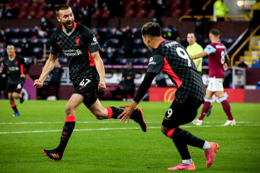Pemain Liverpool Nathaniel Phillips (kiri) merayakan golnya ke gawang Burnley bersama Roberto Firmino.