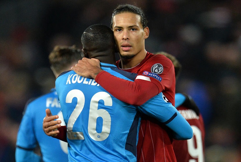 Pemain Liverpool Virgil van Dijk memeluk pemain Napoli Kalidou Koulibaly usai pertandingan Liga Champions Grup E di Liverpool, Rabu (27/11).