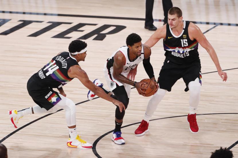 Pemain Los Angeles Clippers Paul George (tengah) berupaya melewati dua pemain Denver Nuggets dalam pertandingan play-off NBA, Selasa (8/9).